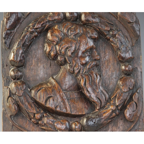 410 - A mid 16th century oak Romayne type carved oak panel, design with a bearded male within circular fol... 