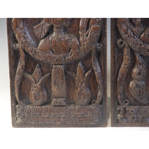 412 - A pair of oak Romayne type panels, each designed with a female holding a single flower within a laur... 