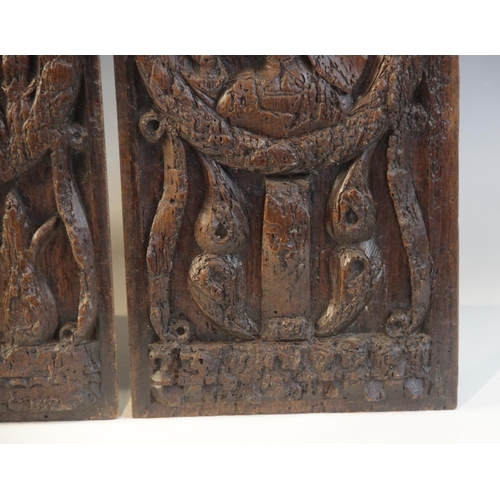 412 - A pair of oak Romayne type panels, each designed with a female holding a single flower within a laur... 