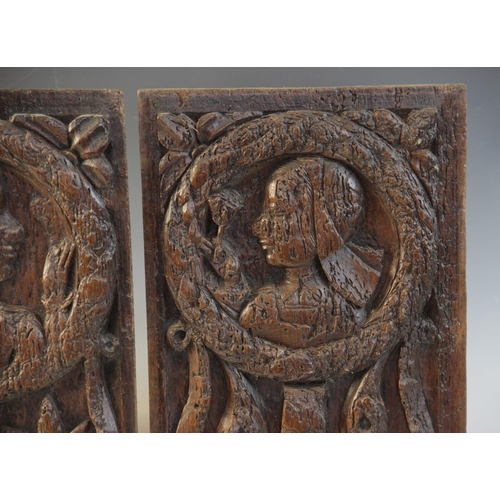 412 - A pair of oak Romayne type panels, each designed with a female holding a single flower within a laur... 