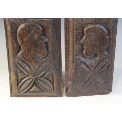 414 - A pair of 16th century oak naïve carved panels, circa 1550, each carved with a profile mask and leaf... 