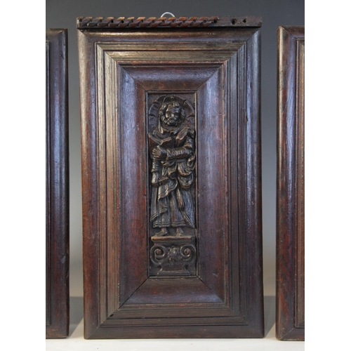 419 - Three carved oak Flemish panels of saints, circa 1600, each Saint carved standing upon a scroll plin... 