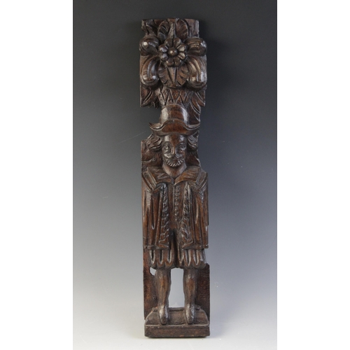 421 - A James I carved oak figural term, carved with a well dressed gentleman modelled standing topped wit... 