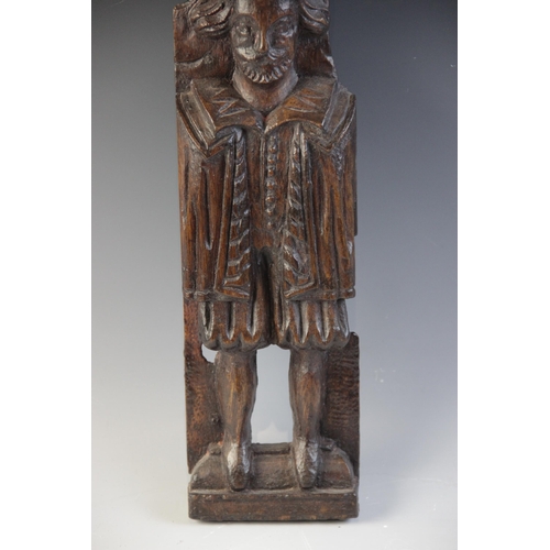 421 - A James I carved oak figural term, carved with a well dressed gentleman modelled standing topped wit... 