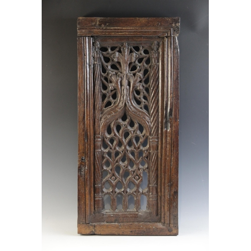 423 - An early 16th century carved oak and pierced tracery panel, circa 1500, the rectangular panel flanke... 