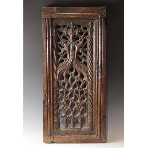 423 - An early 16th century carved oak and pierced tracery panel, circa 1500, the rectangular panel flanke... 