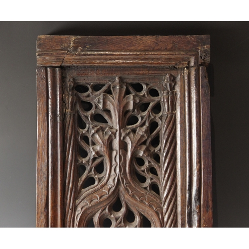 423 - An early 16th century carved oak and pierced tracery panel, circa 1500, the rectangular panel flanke... 