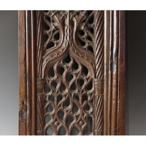 423 - An early 16th century carved oak and pierced tracery panel, circa 1500, the rectangular panel flanke... 