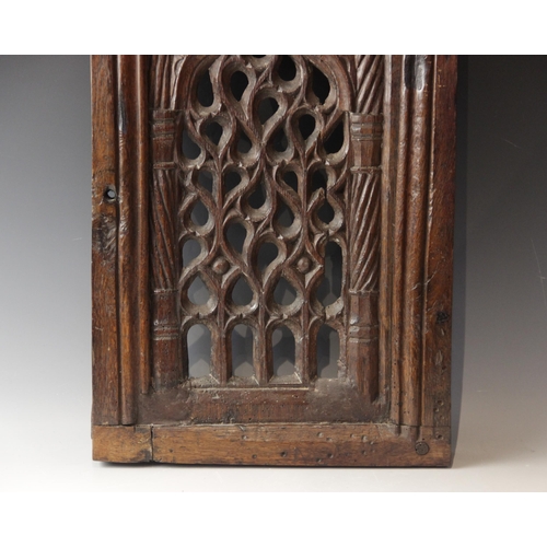 423 - An early 16th century carved oak and pierced tracery panel, circa 1500, the rectangular panel flanke... 