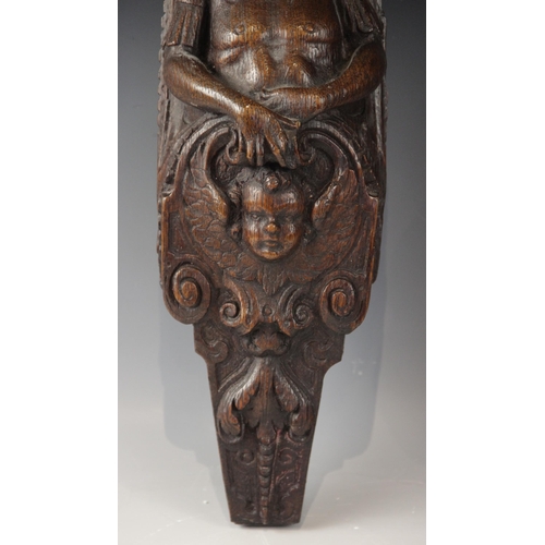 436 - A pair of 17th century oak figural terms, Flemish, each carved with a male bust wearing a hat above ... 