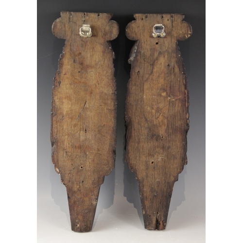 436 - A pair of 17th century oak figural terms, Flemish, each carved with a male bust wearing a hat above ... 