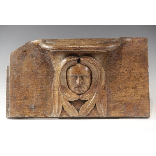 437 - A late 15th century carved oak misericord, carved with a central green man below the seat, 48cm high... 