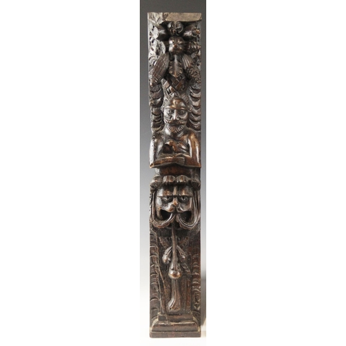 438 - An early 17th century carved walnut term, circa 1630, carved with a male holding a bird, atop a lion... 