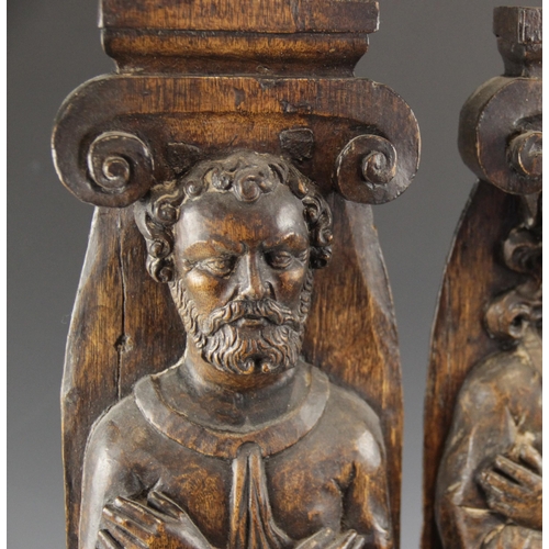 440 - A pair of 17th century carved oak figural terms, Flemish, one male, the other female, both with fold... 