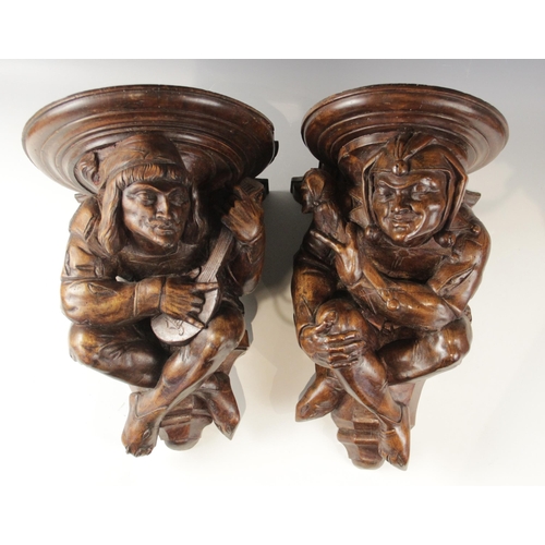 442 - A pair of walnut beam ends, in the 16th century manner, one modelled as a jester the other a musicia... 