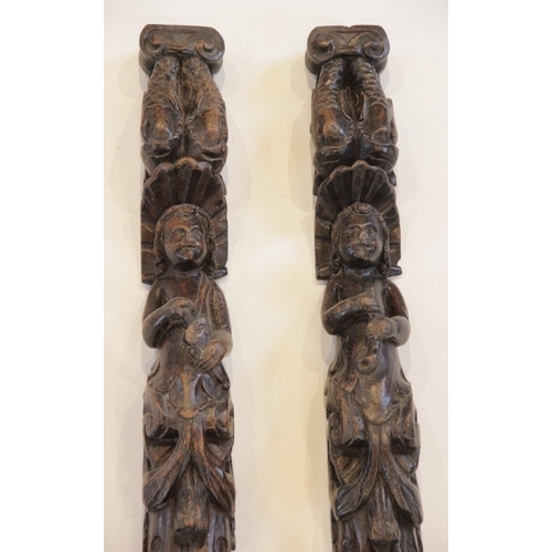 445 - A pair of carved oak pilasters, Flemish, each designed with a figure topped with paired dolphins, 10... 