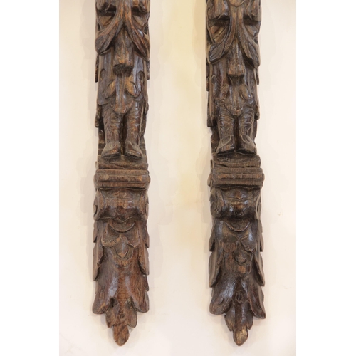 445 - A pair of carved oak pilasters, Flemish, each designed with a figure topped with paired dolphins, 10... 