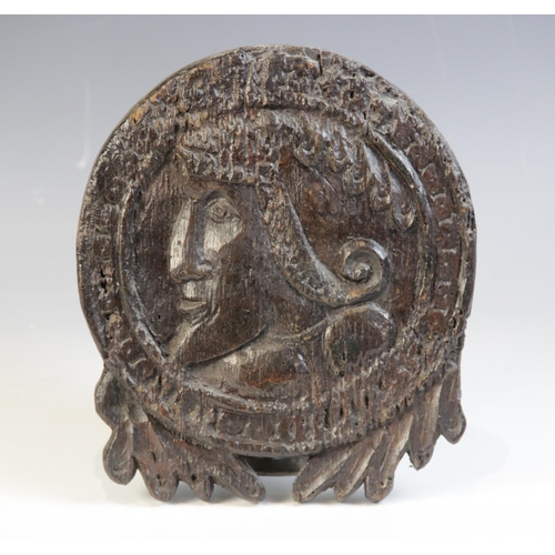 449 - An early 16th century carved oak Romayne type roundel, carved with a male in profile hung with styli... 