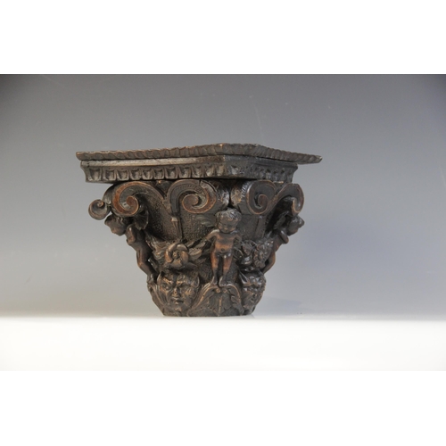 452 - A 16th/17th century carved oak Corinthian column capital, 25.5cm high, with a walnut cherub carved c... 