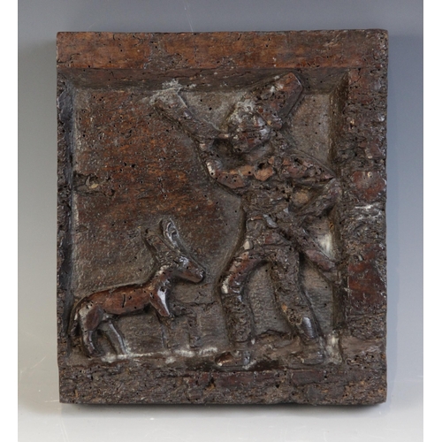 454 - An early 16th century walnut naïve carved square panel, depicting a male blowing a horn with a deer,... 