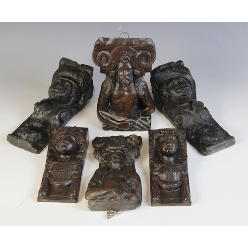 458 - A group of seven oak figural corbels, including a pair of male masks with plumed headdress 20cm high... 