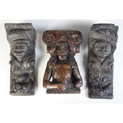 458 - A group of seven oak figural corbels, including a pair of male masks with plumed headdress 20cm high... 