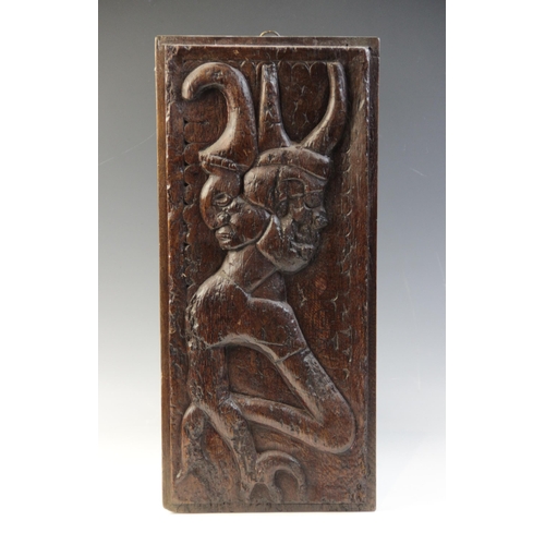 463 - A 16th century carved oak panel, carved with a grotesque beast against a naïve scalloped and foliate... 