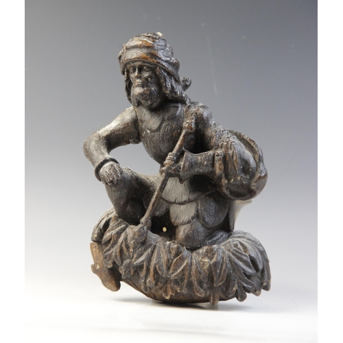 464 - A carved oak hanging figure, circa 1600, carved as a kneeling man holding a staff, upon acanthus car... 