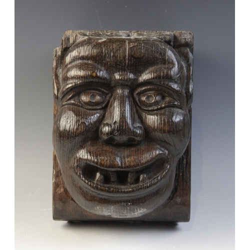 465 - A late 15th century grotesque figural corbel, designed as a male smiling and bearing his teeth, 23.5... 