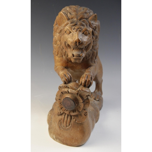 477 - A carved beech figure of a lion, modelled standing with paws upon a stump carved with a rose (later ... 