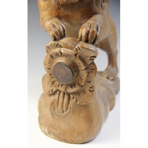 477 - A carved beech figure of a lion, modelled standing with paws upon a stump carved with a rose (later ... 