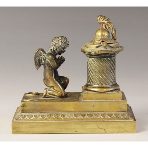 48 - A brass desk inkwell, 19th century, designed as a cherub kneeling before a memorial plinth, surmount... 