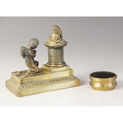 48 - A brass desk inkwell, 19th century, designed as a cherub kneeling before a memorial plinth, surmount... 