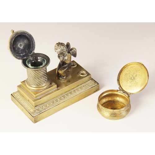 48 - A brass desk inkwell, 19th century, designed as a cherub kneeling before a memorial plinth, surmount... 