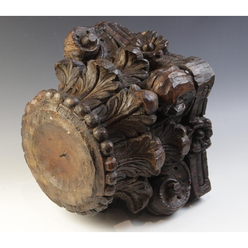 484 - A 16th century carved oak column capital, of square section and leaf carved, 27cm high x 28cm x 28cm