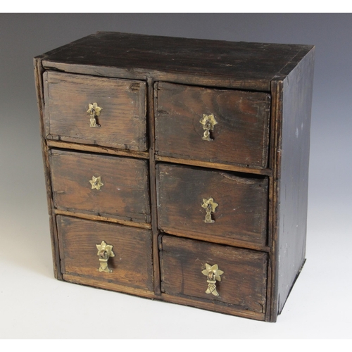 500 - A stained hardwood table top chest, formed from six drawers, contents to include; glass decanter sto... 