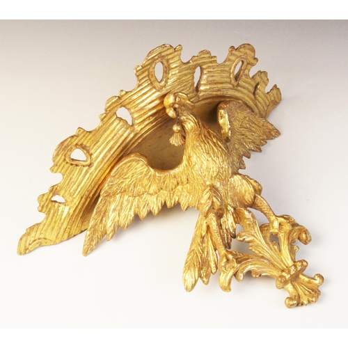 501 - A late 19th/early 20th century giltwood figural wall bracket, modelled as an eagle with wings outstr... 