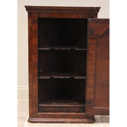 519 - An early 18th century and later, figured walnut hanging corner cupboard, the single straight front f... 