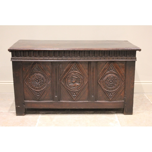 520 - A 17th century oak coffer, the hinged cover above a nulled frieze and three panels, the central pane... 