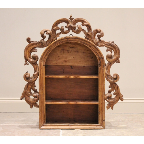 523 - An 18th century and later constructed pine niche, of enclosed arched form with a carved scrolling fo... 