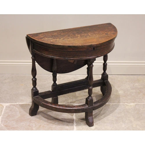 526 - A late 17th / early 18th century and later, circular oak single drop leaf table, the hinged top open... 