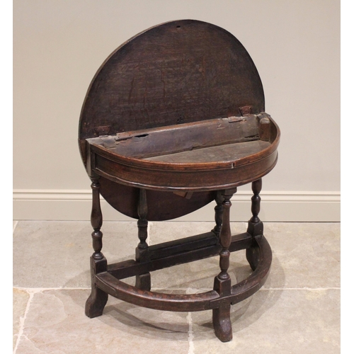 526 - A late 17th / early 18th century and later, circular oak single drop leaf table, the hinged top open... 