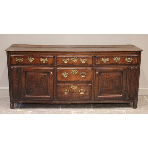 530 - A George II oak dresser base, the rectangular top with inverted front corners over three mahogany cr... 