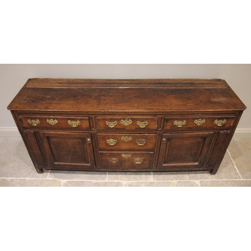 530 - A George II oak dresser base, the rectangular top with inverted front corners over three mahogany cr... 