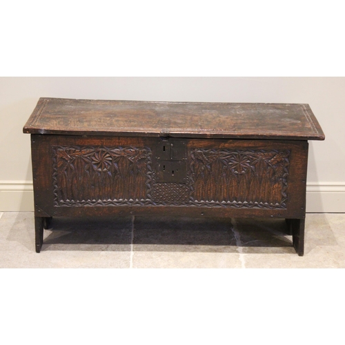 550 - A 16th/17th century oak six plank coffer, the hinged cover with incised channelled detail, above the... 