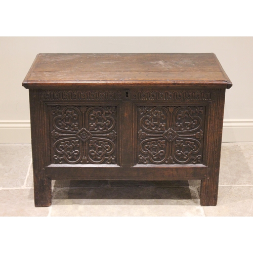 552 - A 17th century oak coffer, the twin front panels carved with an interlaced and cordate design, flank... 