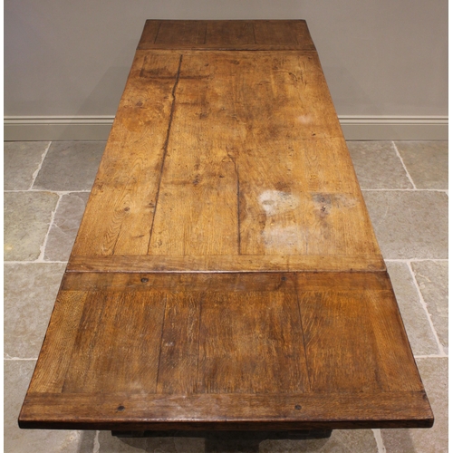 553 - A 17th century and later oak draw leaf refectory type table, the later rectangular cleated top and d... 