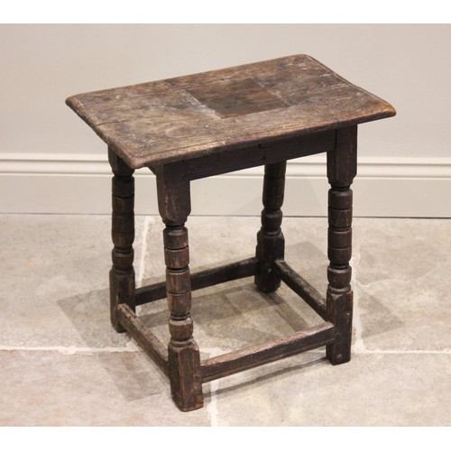 562 - An 18th century oak joint stool, the rectangular moulded top raised raised upon turned tapering and ... 