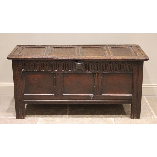 569 - A 17th century oak coffer, the four panel top above a nulled frieze and three front panels, raised u... 