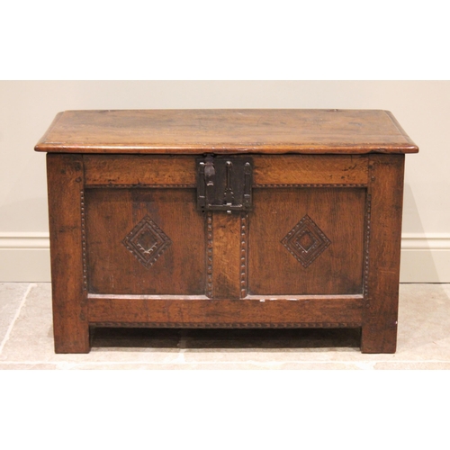 571 - An 18th century oak coffer of cottage proportions, the rectangular moulded top above twin panels eac... 